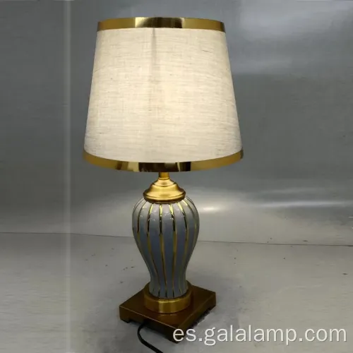 Elegante lámpara de mesa de cerámica con base de metal dorado